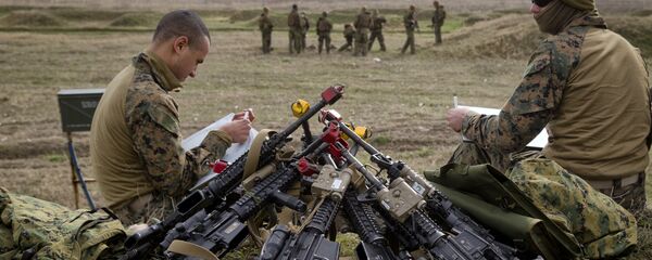 US Marines sit by a pile of assault rifles - Sputnik International