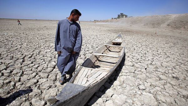 In this photo taken Friday, March 27, 2009, Akeed Abdullah stands next to his boat in a dried marsh in Hor al-Hammar in southern Iraq - Sputnik International
