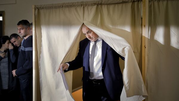 Bulgarian ex-Premier Boiko Borisov, leader of the center-right GERB party, is illuminated by a a photographer's flash as he exits a voting cabin, in Sofia, Bulgaria, Sunday, March 26, 2017 - Sputnik International