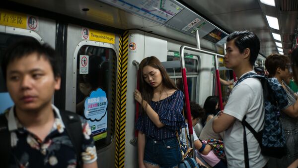 A woman sleeps as she stands during her commute on an underground MTR train in Hong Kong on July 18, 2016 - Sputnik International