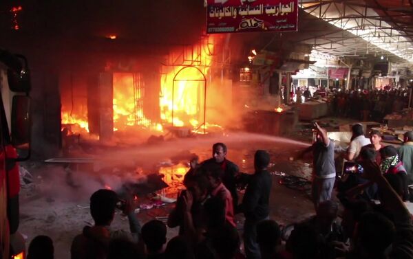 In this image taken from a video footage, multiple market stalls are on fire while people try to tackle it at Nabi Younus market in east Mosul, Iraq, Sunday, March 26, 2017 - Sputnik International