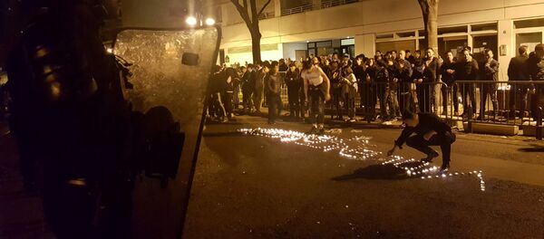 Youths use candles to write the word Violence in the road in front of a line of riot police outside the commisariat of the 19th Arrondissement (District) of Paris late on March 27, 2017, during clashes in the wake of the death of a Chinese national during a police intervention. Youths use candles to write the word Violence in the road in front of a line of riot police outside the commisariat of the 19th Arrondissement (District) of Paris late on March 27, 2017, during clashes in the wake of the death of a Chinese national during a police intervention. - Sputnik International