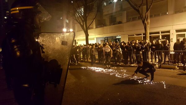 Youths use candles to write the word Violence in the road in front of a line of riot police outside the commisariat of the 19th Arrondissement (District) of Paris late on March 27, 2017, during clashes in the wake of the death of a Chinese national during a police intervention. - Sputnik International