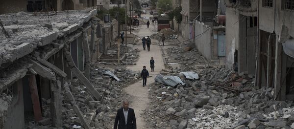 Iraqi civilians walk in a neighborhood recently liberated by Iraqi security forces on the western side of Mosul, Iraq Iraqi civilians walk in a neighborhood recently liberated by Iraqi security forces on the western side of Mosul, Iraq - Sputnik International