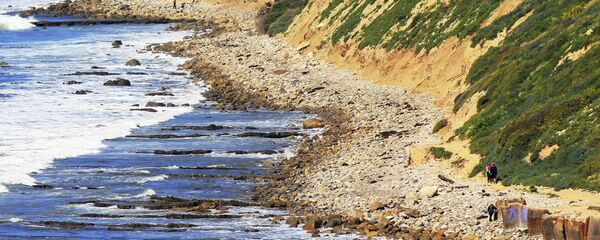 In this Sunday, March 26, 2017, photo, waves roll onto boulders at the foot of a sea cliff near Royal Palms Beach in the San Pedro area of Los Angeles. - Sputnik International