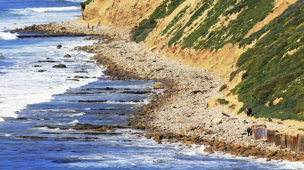 In this Sunday, March 26, 2017, photo, waves roll onto boulders at the foot of a sea cliff near Royal Palms Beach in the San Pedro area of Los Angeles. - Sputnik International