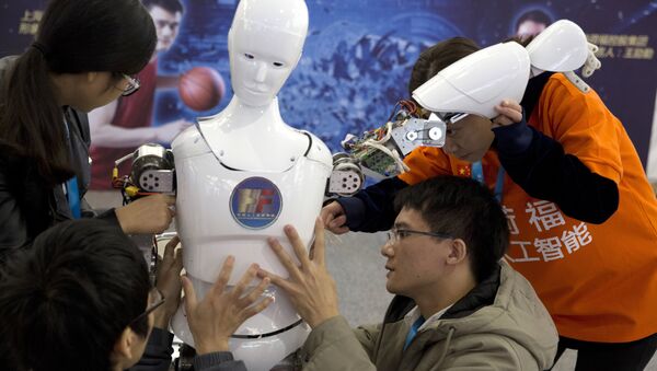 Chinese students work on the Ares, a humanoid bipedal robot designed by them with fundings from a Shanghai investment company, displayed during the World Robot Conference in Beijing. (File) - Sputnik International