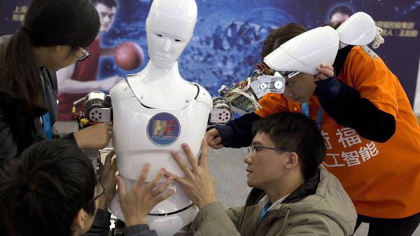 Chinese students work on the Ares, a humanoid bipedal robot designed by them with fundings from a Shanghai investment company, displayed during the World Robot Conference in Beijing. (File) - Sputnik International