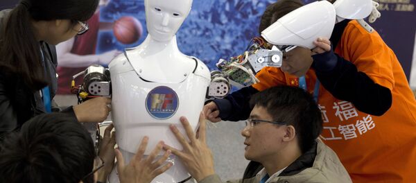 Chinese students work on the Ares, a humanoid bipedal robot designed by them with fundings from a Shanghai investment company, displayed during the World Robot Conference in Beijing. (File) - Sputnik International