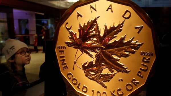 A visitor to the Royal Canadian Mint looks at a 100 kg solid gold coin during the Vancouver 2010 Winter Olympics - Sputnik International