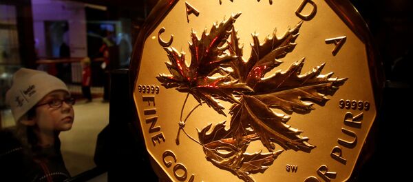 A visitor to the Royal Canadian Mint looks at a 100 kg solid gold coin during the Vancouver 2010 Winter Olympics - Sputnik International
