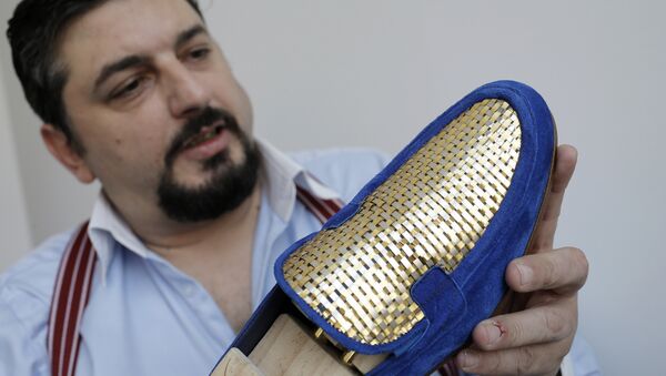 Antonio Vietri, artisan and founder of A&V Fashion, shows a man shoe as part of his collection Gold on March 16, 2017 in his workshop in Turin. Antonio Vietri made a crazy bet: selling 24-carat gold plaited shoes targeting customers of the Gulf countries. - Sputnik International