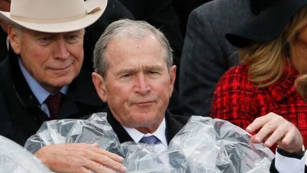 George W. Bush struggles to put on a poncho during Donald Trump's inauguration. - Sputnik International
