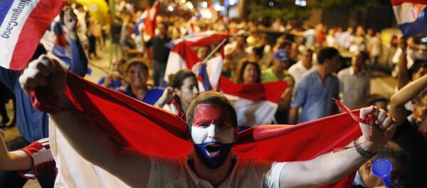 A youth holds a national Paraguay national flag as he marches with others in protest against the project to change the country's constitution, in Asuncion, Paraguay, Thursday, March 30, 2017. - Sputnik International