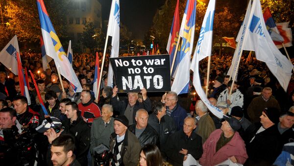 An opposition supporter holds a banner that reads No to war - no to NATO during protest in downtown Podgorica, Montenegro, Saturday, Dec. 12, 2015 - Sputnik International