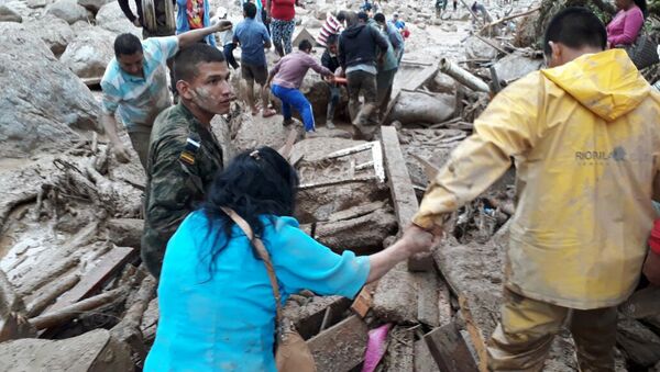 In this handout photo released by the Colombian National Army, soldiers and rescue workers evacuate residents from the area in Mocoa, Colombia, Saturday, April 1, 2017, after an avalanche of water from an overflowing river swept through the city as people slept. - Sputnik International