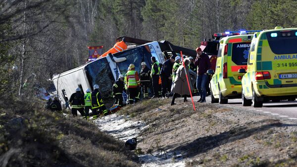 Rescue workers are seen at the site where a bus carrying school children and adults rolled over on a road close to the town of Sveg, in northern Sweden April 2, 2017 - Sputnik International