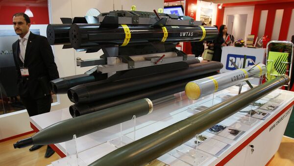 An exhibitor staff stands beside missiles and rockets manufactured by Roketsan in Turkey at the 12th Defence Services Asia Exhibition and Conference in Kuala Lumpur, Malaysia, Monday, April 19, 2010 - Sputnik International