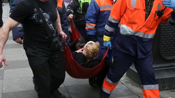 An injured person is helped by emergency services outside Sennaya Ploshchad metro station, following explosions in two train carriages at metro stations in St. Petersburg, Russia April 3, 2017 - Sputnik International