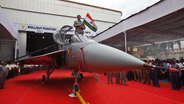 A Hindustan Aeronautics Limited engineer hurls the Indian flag as he stands in the cockpit of India's first indigenous naval Light Combat Aircraft LCA (Navy) NP1 during its roll out ceremony in Bangalore, India, Tuesday, July 6, 2010 - Sputnik International