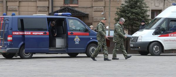Members of the security services walk past a vehicle of Russia's Investigative Committee outside Sennaya Ploshchad metro station after an explosion tore through a train carriage in the St. Petersburg metro system, in St. Petersburg, Russia April 3, 2017 - Sputnik International