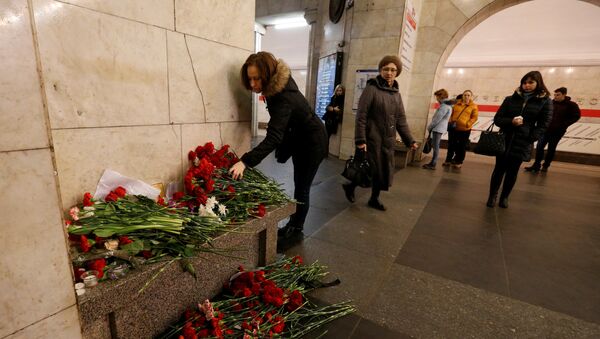 A woman lays flowers in memory of victims of a blast in St.Petersburg metro, at Tekhnologicheskiy institut metro station in St. Petersburg, Russia, April 4, 2017 - Sputnik International