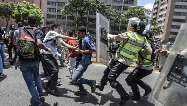 Venezuela's opposition activists clash with riot police agents during a protest against Nicolas Maduro's government in Caracas on April 4, 2017 - Sputnik International