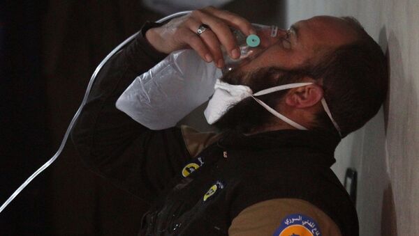 A civil defence member breathes through an oxygen mask, after what rescue workers described as a suspected gas attack in the town of Khan Sheikhoun in rebel-held Idlib, Syria April 4, 2017. - Sputnik International