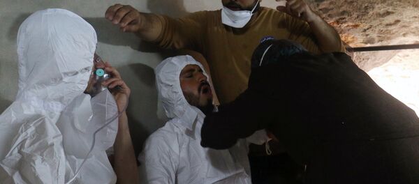 A man breathes through an oxygen mask as another one receives treatments, after what rescue workers described as a suspected gas attack in the town of Khan Sheikhoun in rebel-held Idlib, Syria - Sputnik International