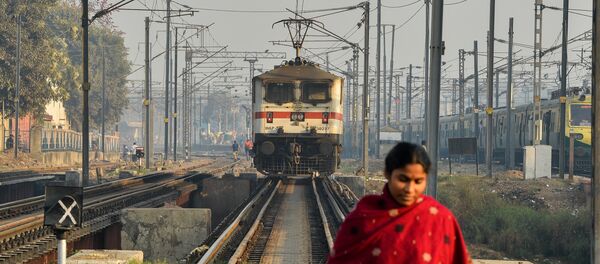 An Indian woman crosses rail tracks An Indian woman crosses rail tracks - Sputnik International
