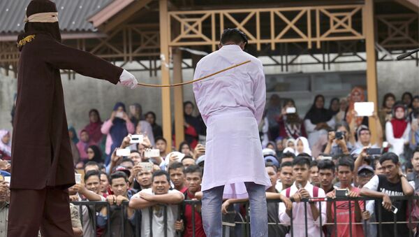 In this Monday, March 20, 2017 photo, a Sharia law official whips a man convicted of adultery with a rattan cane in Banda Aceh, Indonesia. - Sputnik International