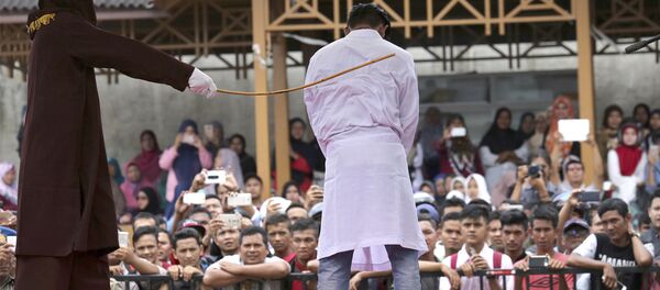In this Monday, March 20, 2017 photo, a Sharia law official whips a man convicted of adultery with a rattan cane in Banda Aceh, Indonesia. In this Monday, March 20, 2017 photo, a Sharia law official whips a man convicted of adultery with a rattan cane in Banda Aceh, Indonesia. - Sputnik International