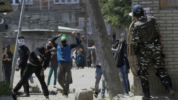 Kashmiri protesters throw stones on Indian security men outside a poling station during a by-election to an Indian Parliament seat in Srinagar, Indian controlled Kashmir, Sunday, April. 9, 2017 - Sputnik International