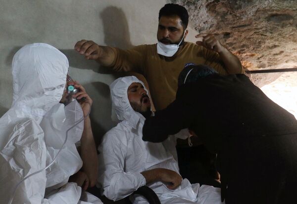 A man breathes through an oxygen mask as another one receives treatments, after what rescue workers described as a suspected gas attack in the town of Khan Sheikhoun in Idlib, Syria April 4, 2017 - Sputnik International