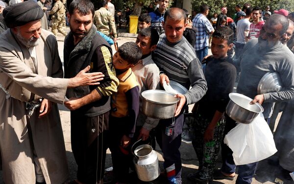 Civilians queue to collect food during food delivery in Western Mosul, Iraq March 30, 2017 - Sputnik International