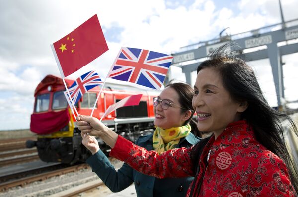 People wave a Chinese and a Union flags as they pose for photographs during a photcall to witness the departure of a freight train transporting containers laden with goods from the UK, from DP World London Gateway's rail freight depot in Corringham, east of London, on April 10, 2017, enroute to Yiwu in the eastern Chinese province of Zhejiang.  - Sputnik International