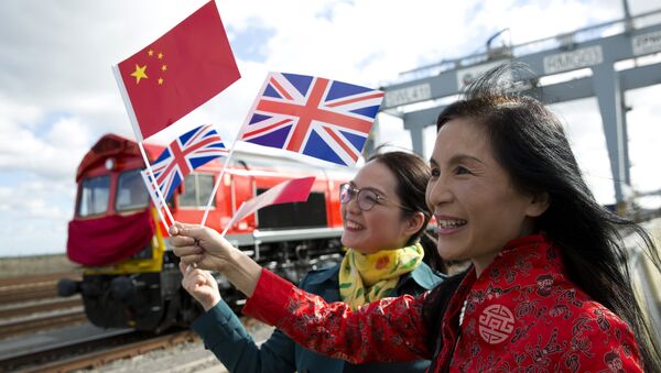 People wave a Chinese and a Union flags as they pose for photographs during a photcall to witness the departure of a freight train transporting containers laden with goods from the UK, from DP World London Gateway's rail freight depot in Corringham, east of London, on April 10, 2017, enroute to Yiwu in the eastern Chinese province of Zhejiang. - Sputnik International