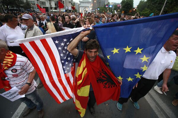 A protestor holds the flags of the United States, Macedonia, Albania and the European Union while attending a march through downtown Skopje, Macedonia, Monday, April 18, 2016 A protestor holds the flags of the United States, Macedonia, Albania and the European Union while attending a march through downtown Skopje, Macedonia, Monday, April 18, 2016 - Sputnik International