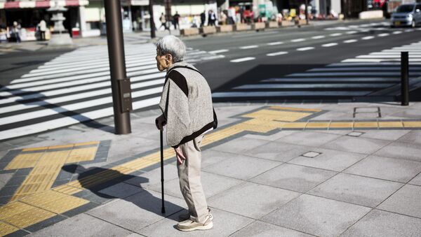 A Japanese elderly woman waits for the traffic light to cross the street in Nagano, northwest of the capital Tokyo on November 7, 2016 - Sputnik International