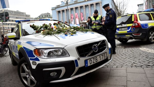 Flowers lay on a police car at Hotorget square near the crime scene in central Stockholm on April 8, 2017, the day after a hijacked beer truck plowed into pedestrians on Drottninggatan and crashed into Ahlens department store, killing four people, injuring 15 others - Sputnik International