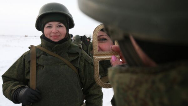 A female soldier looks in the mirror ahead of a firing exercise at a shooting range of a Russian Airborne Forces Training Center. File photo - Sputnik International