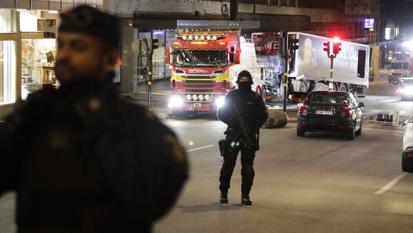 Police officers guard the scene as a truck is pulled away by a service car after it was driven into a department store in Stockholm, Sweden, Saturday, April 8, 2017 - Sputnik International