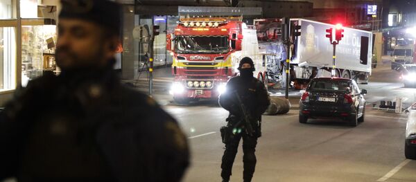 Police officers guard the scene as a truck is pulled away by a service car after it was driven into a department store in Stockholm, Sweden, Saturday, April 8, 2017 - Sputnik International