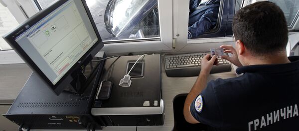 In this Oct. 22, 2012 photo a Serbian border police officer checks the identification of passengers as the car is crossing from Macedonia to the Serbia, at the Presevo border crossing, 380 kms south of Belgrade, Serbia. - Sputnik International