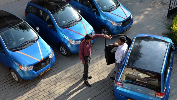 An employee of Indian company Carzonrent interacts with a prospective customer ahead of hiring a Mahindra Reva electric car in Bangalore - Sputnik International