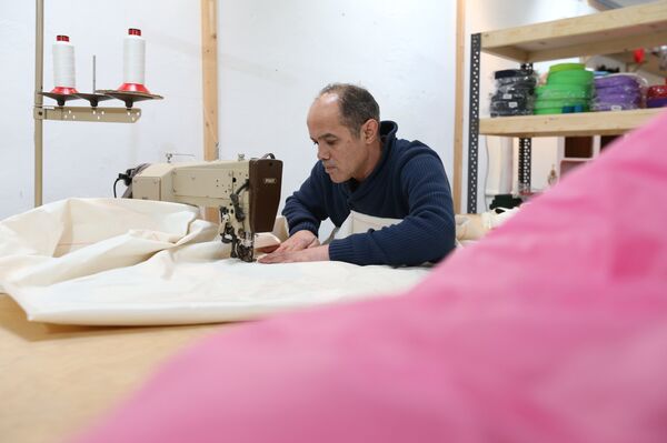 Syrian refugee Mohammed Alsahani used to make curtains in Damascus and now works with the sailmaker Coastworxx near the port of Kiel in Germany. - Sputnik International