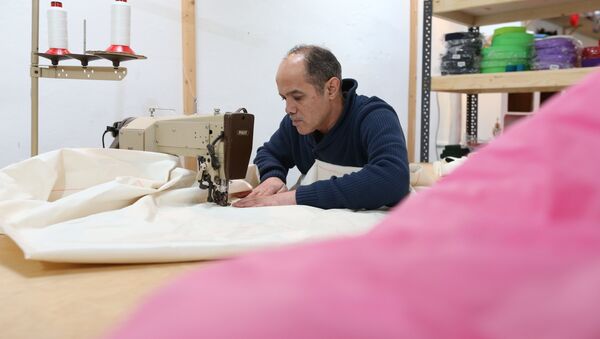 Syrian refugee Mohammed Alsahani used to make curtains in Damascus and now works with the sailmaker Coastworxx near the port of Kiel in Germany. - Sputnik International