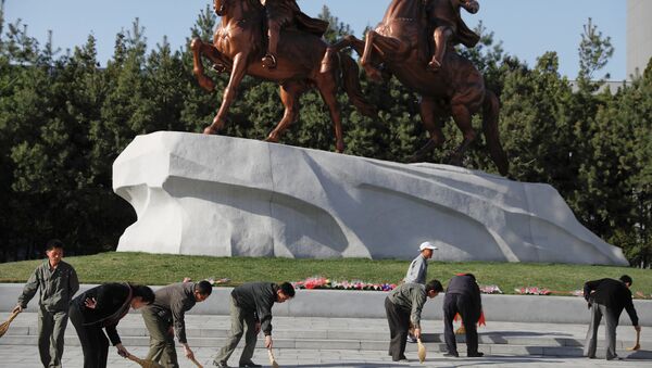 People sweep in front of statues of former North Korean leaders Kim Il Sung and Kim Jong Il in central Pyongyang, North Korea April 12, 2017. - Sputnik International