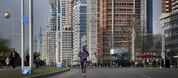 A participant of the Pyongyang marathon runs down Mirae Scientist Street on Sunday, April 9, 2017, in Pyongyang, North Korea. A participant of the Pyongyang marathon runs down Mirae Scientist Street on Sunday, April 9, 2017, in Pyongyang, North Korea. - Sputnik International
