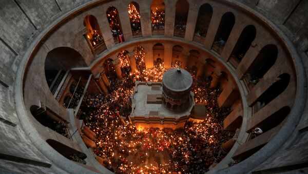 Worshippers hold candles as they take part in the Christian Orthodox Holy Fire ceremony at the Church of the Holy Sepulchre in Jerusalem's Old City - Sputnik International